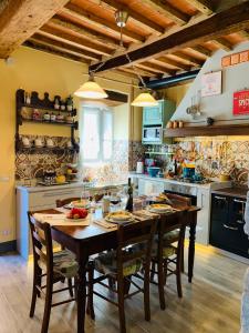 una cocina con mesa de madera y sillas. en Casa Emma Fiattone in Garfagnana, en Fiattone