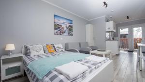 1 dormitorio blanco con 1 cama y cocina en U Dorotki - Apartamenty i Pokoje, en Sandomierz