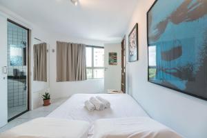 Un dormitorio blanco con dos toallas en una cama. en Ótimo Flat Bairro da Jaqueira Recife até 3 pessoas O Coração Verde da Cidade PBO902, en Recife 13 fotos más