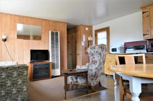 a living room with a table and a chair at Baileys Sunset Cottages in Baileys Harbor