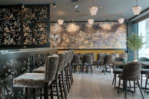 a dining room with chairs and a large painting on the wall at Dune Resort - B in Mielno