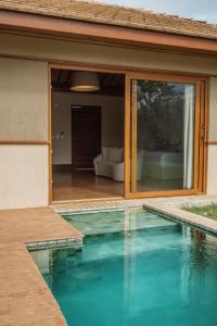 una piscina frente a una casa en Colina Pousada SPA, en Fernando de Noronha