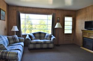 a living room with a couch and a chair and a fireplace at Baileys Sunset Cottages in Baileys Harbor