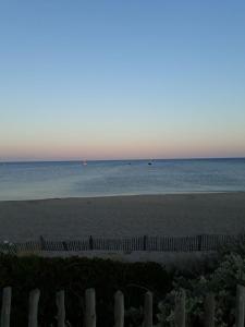 a beach with a fence and the ocean at Luxury Penthouse in Naturiste; FKK, Nudist Village in Cap d'Agde