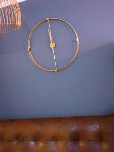 a gold clock hanging on a blue wall at Estudio Vigo Centro Lux in Vigo
