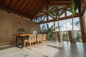 a dining room with a table and chairs and a large window at Colina Pousada SPA in Fernando de Noronha