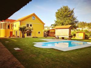 a backyard with a swimming pool and a house at Casas do Prazo - Turismo Rural in Nogueira