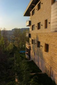 ein Backsteingebäude mit einem Balkon an der Seite in der Unterkunft Austria Luxury Apartments, Faraya Hotel in Fārayyā