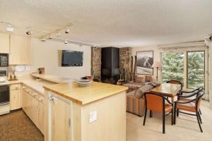 eine Küche und ein Wohnzimmer mit einem Tisch und Stühlen in der Unterkunft Shadowbrook 204 in Snowmass Village