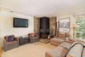 ein Wohnzimmer mit Sofas, einem TV und einem Kamin in der Unterkunft Shadowbrook 204 in Snowmass Village