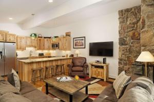 a kitchen and living room with a couch and a table at Shadowbrook 505 in Snowmass Village