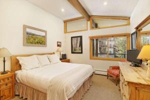 a bedroom with a bed and a desk and a television at Shadowbrook 303 in Snowmass Village