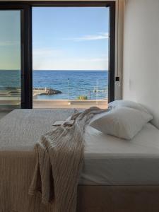 sypialnia z łóżkiem i widokiem na ocean w obiekcie Nuez Villas w mieście Mochlos