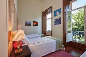 1 dormitorio con 1 cama con lámpara y ventana en Casadacidade en Ponta Delgada