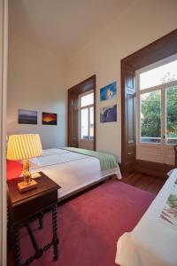 a bedroom with a bed and a table with a lamp at Casadacidade in Ponta Delgada