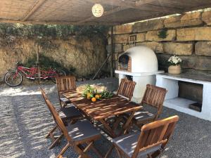 a wooden table with chairs and a pizza oven at Laranjal Farm House - Laranjal Studio 1 in Faro