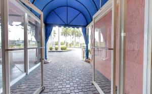 a blue and white building with a blue umbrella at Miami Gardens Inn & Suites in Miami