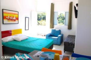 mały pokój z łóżkiem i krzesłem w obiekcie Kitnet Maitinga w mieście Bertioga