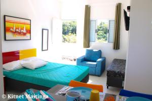 a small room with a bed and a chair at Kitnet Maitinga in Bertioga