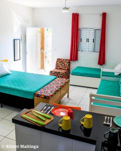 a living room with two beds and a table with a table at Kitnet Maitinga in Bertioga
