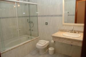 y baño con aseo, ducha y lavamanos. en Pousada Chablis, en Campos do Jordão