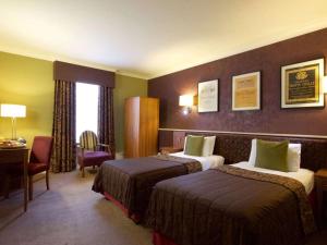 a hotel room with two beds and a desk at Derby Midland Hotel, BW Signature Collection in Derby