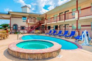 a pool in front of a hotel with blue chairs at SureStay Hotel by Best Western New Braunfels in New Braunfels