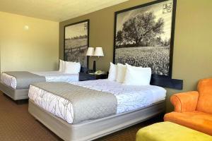 a hotel room with two beds and a chair at SureStay Hotel by Best Western New Braunfels in New Braunfels