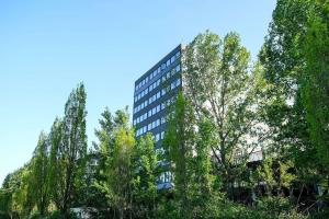 un edificio alto con árboles delante de él en LOFTSTYLE Hotel Hannover, Best Western Signature Collection en Hannover