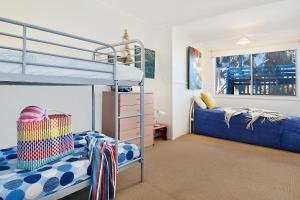 a bedroom with two bunk beds and a ladder at Beach House in Lennox Head