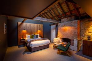 a bedroom with a bed and a brick wall at Moss Hotel in Hobart