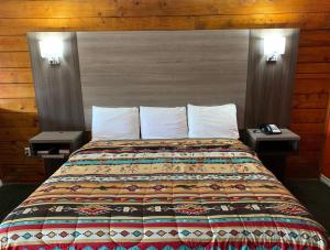 1 cama en una habitación de hotel con 2 mesas en Log Cabin Inn, en Bay Minette