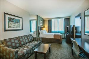 ein Hotelzimmer mit einem Sofa und einem Bett in der Unterkunft Holiday Inn Saskatoon Downtown, an IHG Hotel in Saskatoon