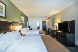 um quarto de hotel com duas camas e uma televisão de ecrã plano em Holiday Inn Saskatoon Downtown, an IHG Hotel em Saskatoon