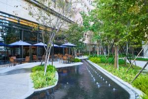 un patio con mesas, sillas y un estanque en Kloud Hotel en Taichung