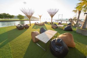 a park with benches and bean bags on the grass at Baan Tah On The Sea in Bang Sare