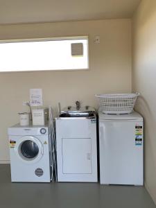 a laundry room with a washing machine and a washer at Amberley Serviced Apartments in Amberley