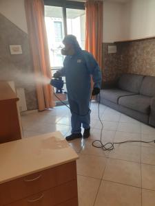 a man standing in a living room with a hose at Bergamo City Apartments in Bergamo