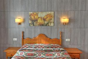 a bedroom with a bed and two lights on the wall at Apartamentos Petronilla in Benasque