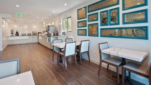une salle à manger avec des tables, des chaises et des peintures murales dans l'établissement Best Western Woodland Hills, à Woodland Hills