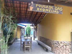 un restaurante con sillas y un letrero que lee rosada dos bronzes en Pousada das Bromélias, en Serra do Cipo