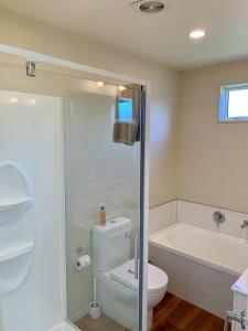 a bathroom with a toilet and a bath tub at Amberley Serviced Apartments in Amberley