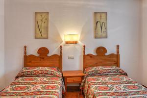 two beds sitting next to each other in a room at Apartamentos Petronilla in Benasque