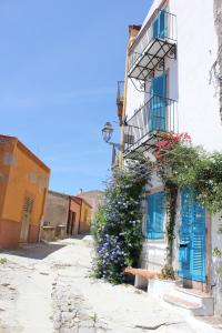 博薩的住宿－布莎酒店，街上有蓝色门和鲜花的建筑