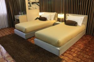 
a hotel room with two beds and two lamps at Prince Plaza II Condotel in Manila
