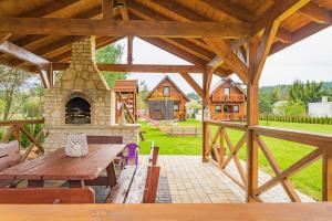 a patio with a stone fireplace and a picnic table at Domki na Jurze in Kroczyce
