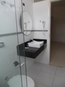 uma casa de banho com um lavatório, um espelho e um WC. em Palace Hotel em Itajubá