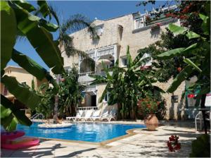 a hotel with a swimming pool in front of a building at Villa Tasos in Acharavi