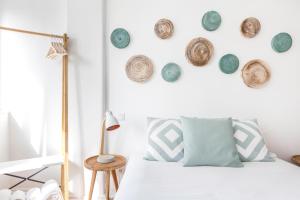 a bedroom with a bed and a wall with hats on it at Stroll to Coffee Shops Near a Renovated Hillside Apartment in Graça in Lisbon
