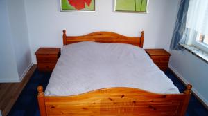 a bed in a bedroom with a wooden bed frame at Ferienwohnung Familie von Seggern in Bispingen